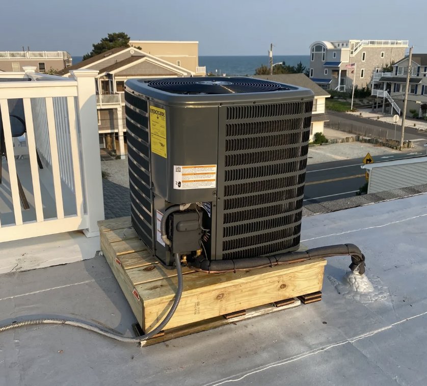 A Goodman AC unit installed on a rooftop with an ocean view by Tom's Heating & Air Conditioning LLC in Lacey Township, NJ.