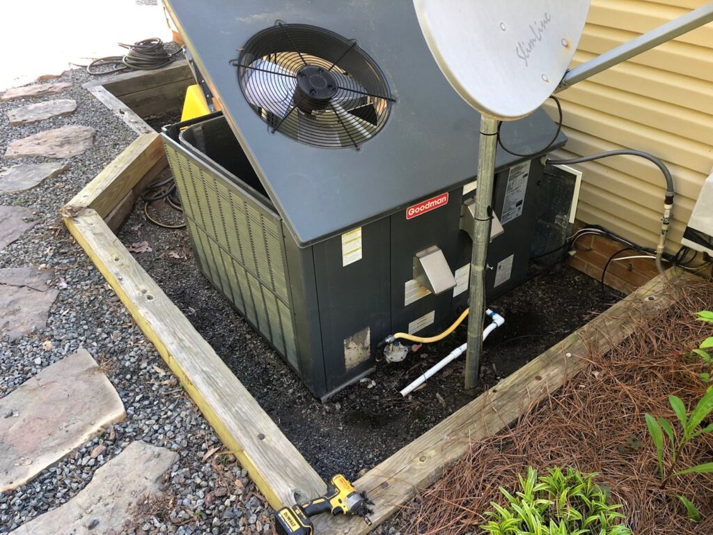 A Goodman outdoor air conditioning unit with its top removed for service by G&G Heating and Air in Portage, MI.