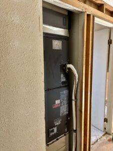 A Goodman air handler unit being installed in a utility closet by Kingdom Heating and Air in Sacramento, CA.