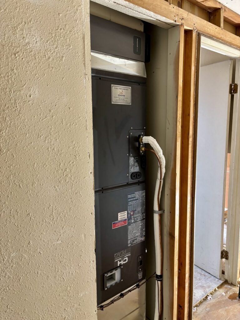 A Goodman air handler unit being installed in a utility closet by Kingdom Heating and Air in Sacramento, CA.