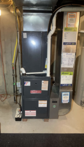 An indoor Goodman furnace and air handler system installed in a utility room by American Team Inc in Warminster, PA