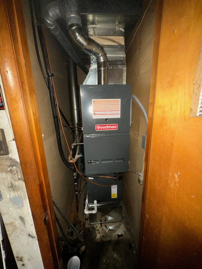 A Goodman furnace and air handler unit installed in a narrow utility space by Breezy Brothers Heating and Cooling in Lafayette, IN.