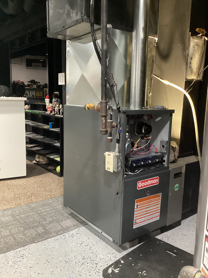 An open Goodman furnace showing internal components during a repair or service by Guzman Heating & Cooling in Milwaukee, WI.