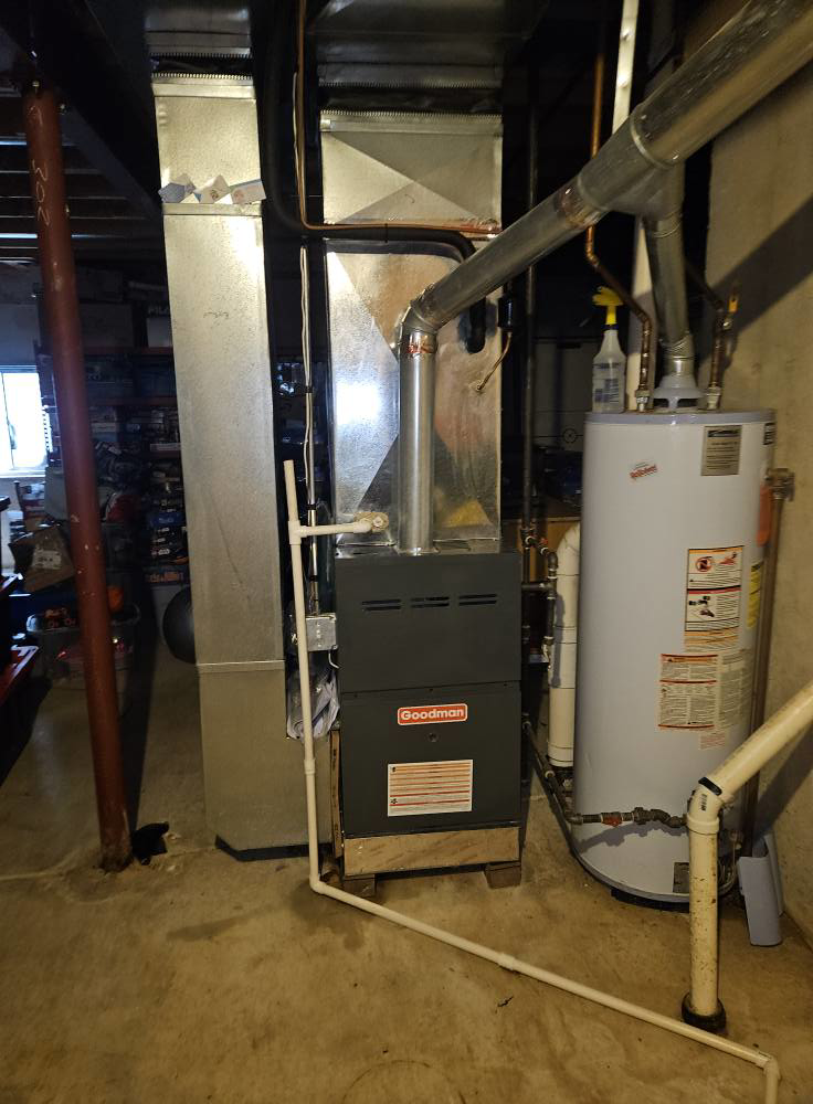 A Goodman furnace and water heater with ductwork installed in a utility room by Dr. Cool Climate Control HVAC in Las Vegas, NV.