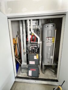 A Goodman furnace and water heater installed in a utility closet by Golden Heating and Air LLC in Arvada, CO.