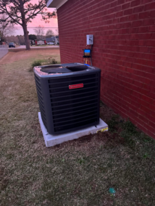 A newly installed Goodman outdoor HVAC condenser unit by Barnie Sales Heating & A/C in Mobile, AL