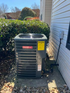 A Goodman outdoor HVAC condenser unit installed next to a building by SJ Conner and Sons Inc in Roanoke, VA