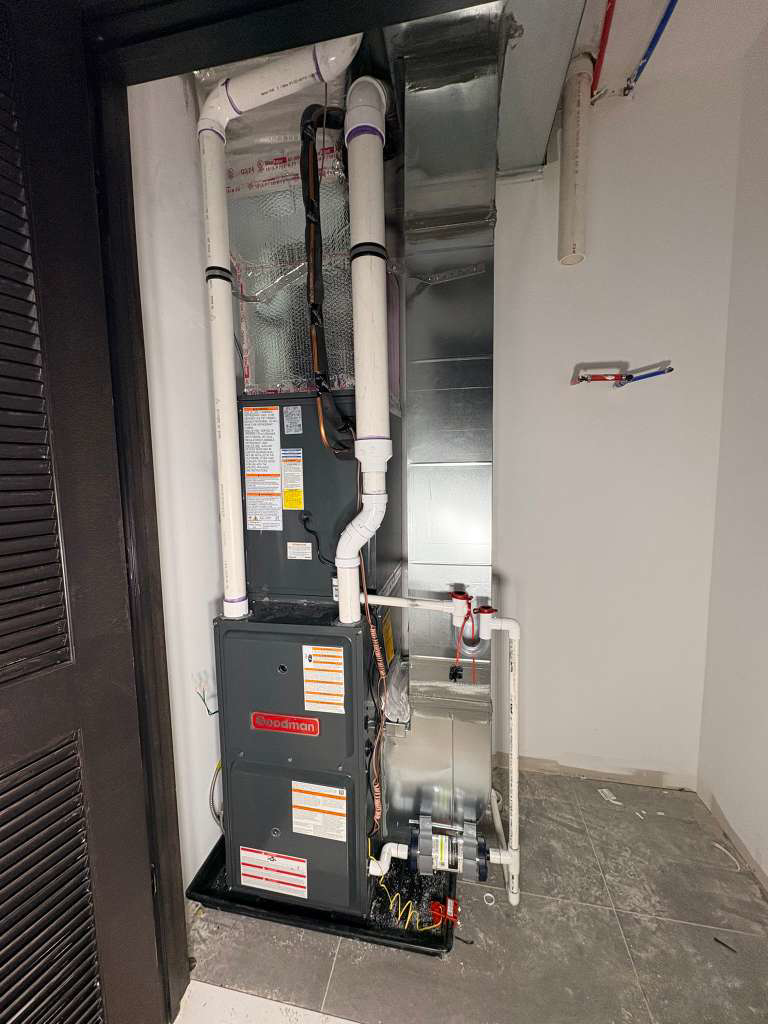 A newly installed Goodman HVAC furnace and air handler unit with ductwork by Fast Air in Zebulon, NC.