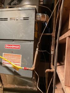 An indoor Goodman furnace or air handler unit with gas lines and ductwork, installed by TJ Mechanical Services LLC in Rock Hill, SC.