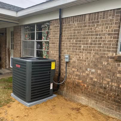 An outdoor Goodman AC unit installed next to a brick house by Fields Cooling Heating Heating & Refrigeration in Foley, AL.