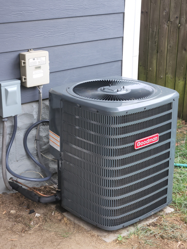 A newly installed Goodman outdoor air conditioning unit next to a home, serviced by HOP 2 IT LLC in Austin, TX.