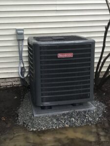 A newly installed Goodman outdoor AC unit next to a residential building by JDL HVAC Services, LLC in Laurel, MD.