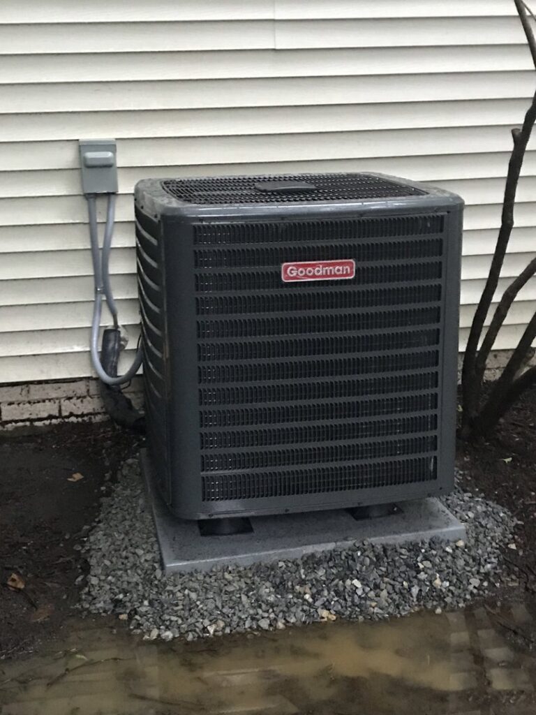 A newly installed Goodman outdoor AC unit next to a residential building by JDL HVAC Services, LLC in Laurel, MD.