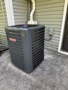 A Goodman outdoor air conditioning unit installed on a concrete pad by Revolution HVAC in Owings Mills, MD.