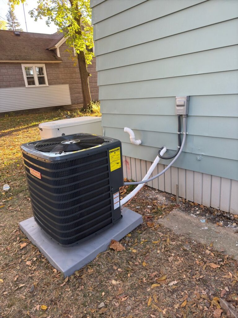 An outdoor Goodman AC unit installed beside a house by Breezy Brothers Heating and Cooling in Lafayette, IN.