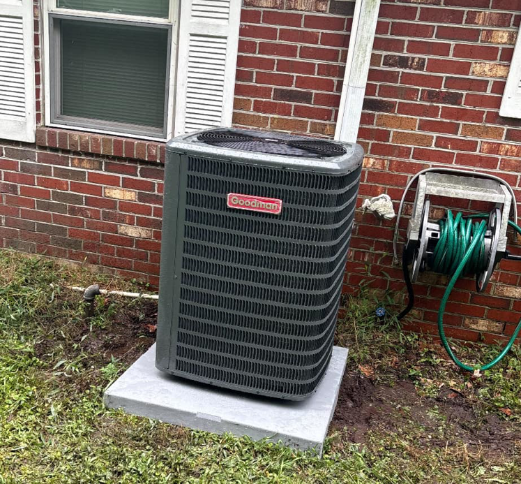A newly installed Goodman outdoor HVAC condenser unit by Greene Mechanical in Holly Springs, GA.