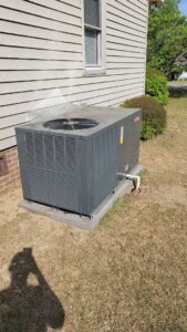 A Goodman outdoor HVAC unit installed next to a house by All American Heating and Air in Warner Robins, GA.