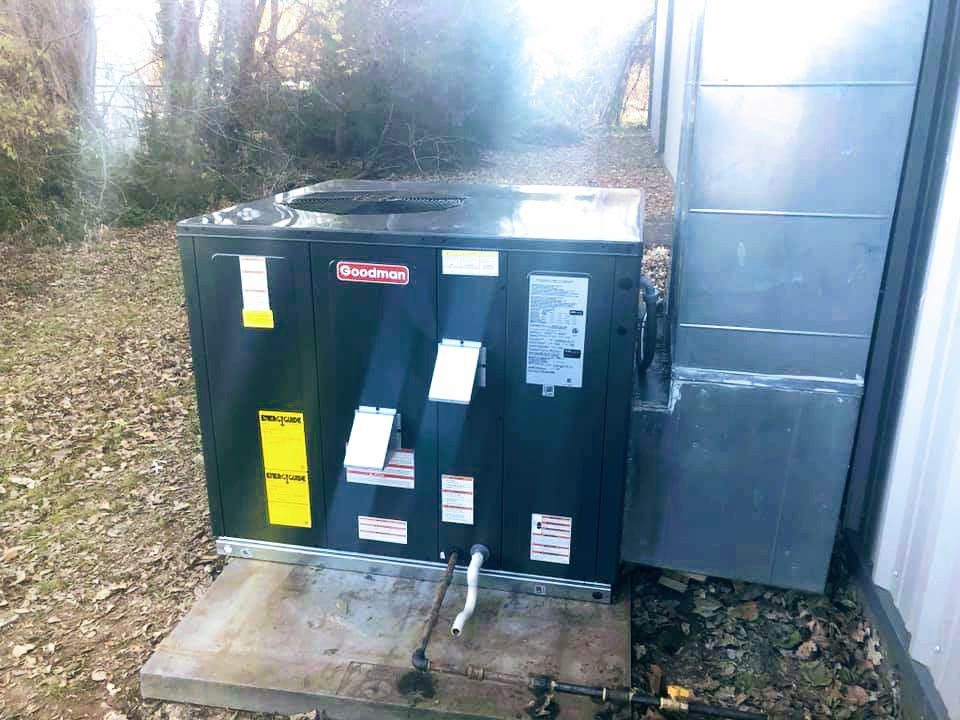 An outdoor Goodman HVAC unit with connecting ductwork installed by Griffin's Heating & Air in Tulsa, OK.