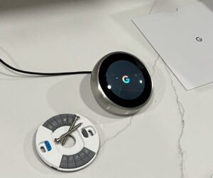 A Google Nest smart thermostat and its mounting plate, ready for installation by HomeWorks Energy in Charlestown, MA.