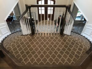 A grand entryway featuring a custom patterned carpet runner installed on a double staircase by Carpet Binding Company in Charlotte, NC.