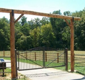Grand wooden gate entrance with a metal gate installed by National Fence and Gate in Ironton, MO.
