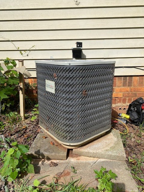 An outdoor GrandAire AC unit being serviced by TJ Mechanical Services LLC in Rock Hill, SC, with tools nearby.