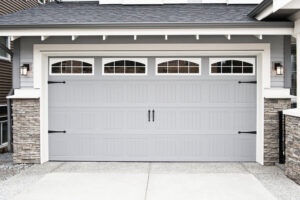 An elegant gray carriage-style garage door with decorative hardware and arched windows by Calavera Garage Doors in Mesa, AZ
