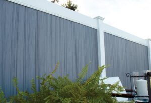 A stylish gray composite privacy fence with white posts and top rail, installed by Western Fence & Landscape Supply in Caldwell, ID.