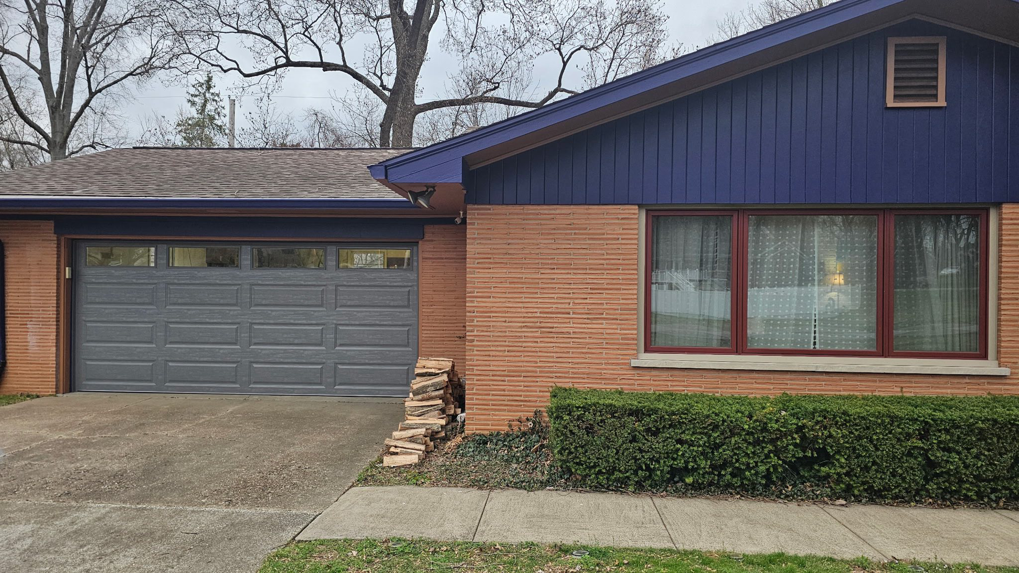 A modern house with a gray garage door and brick siding, installed by A+ Garage Door Repair in Evansville, IN.