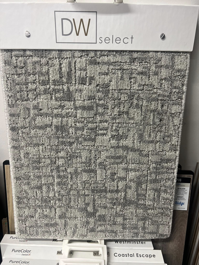A close-up of a gray geometric pattern carpet sample at West Michigan Flooring & Interiors in Byron Center, MI.
