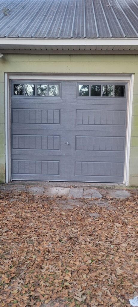 A newly installed gray panel garage door with windows by On Track Garage Doors in Charleston, SC.