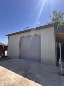 A gray paneled garage door installed on a metal building by 4 Sons Garage Door in Phoenix, AZ.