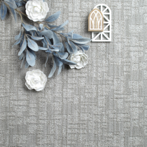 A close-up view of a gray patterned carpet sample with decorative elements from Carpet World Bismarck in Bismarck, ND.
