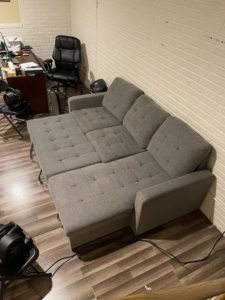 A gray sectional sofa undergoing upholstery cleaning and drying with fans by J&A Citrus-Carpet Tile Cleaning & Auto Detailing in Elkhart, IN.