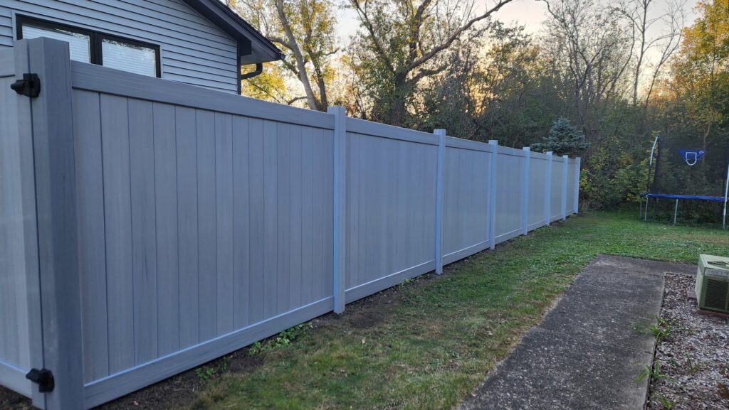 New gray vinyl privacy fence installed in a residential backyard by All Terrain Fence LLC in Waukegan, IL