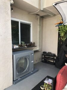 A Gree mini-split condenser unit installed outside a home by Peace & Comfort Heating and Air in San Diego, CA.