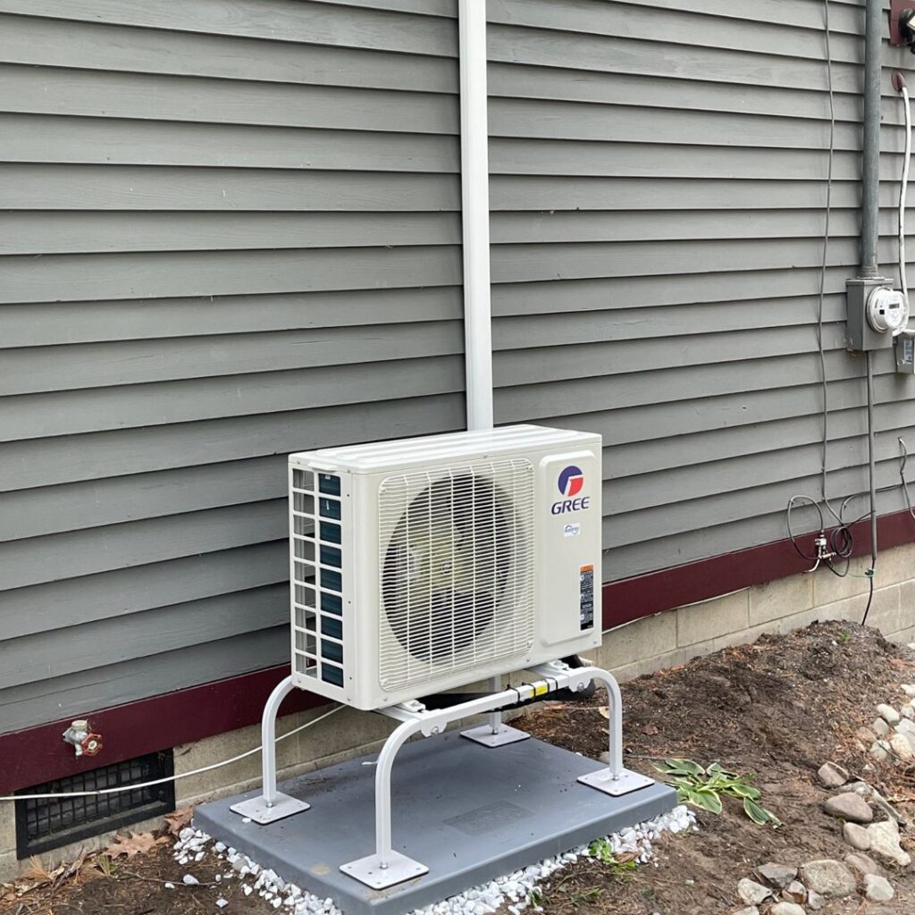 A Gree mini-split outdoor condenser unit installed on a raised stand by Revolution HVAC in Owings Mills, MD.