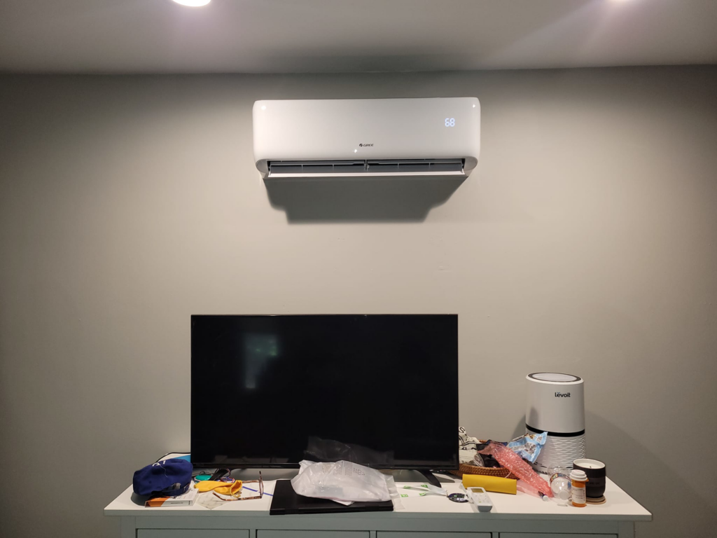 An indoor Gree mini-split unit installed above a television by Vega Heating and Cooling in Kansas City, KS