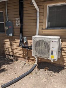 An exterior Gree mini-split outdoor unit with conduit installed by Inspector Rogers LLC in Draper, UT.
