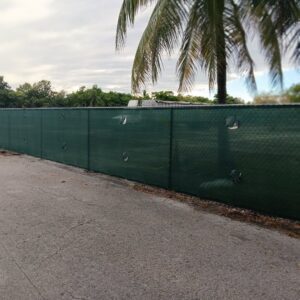 A green chain-link fence with privacy slats running alongside a road, installed by Allende J. Service Corp in Miami, FL.
