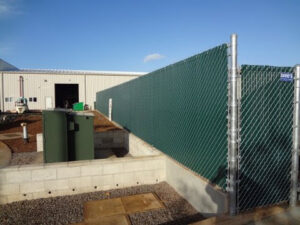 A green chain-link fence with privacy slats installed by David's Fencing Inc. in Waipahu, HI.