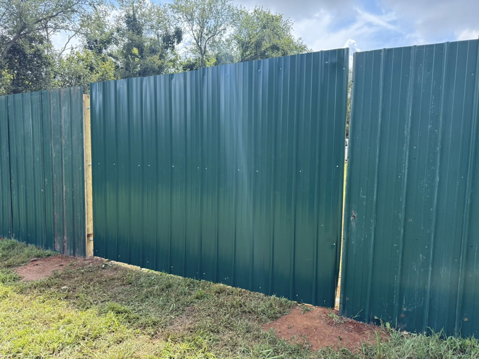 A newly installed dark green corrugated metal privacy fence by JV Fences in Lexington, KY.