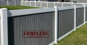 A modern grey and white vinyl privacy fence installed by Complete Fence, LLC in West Chicago, IL