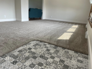 A new grey carpet installation next to patterned tile flooring by CDK Flooring, LLC in Sheboygan, WI.