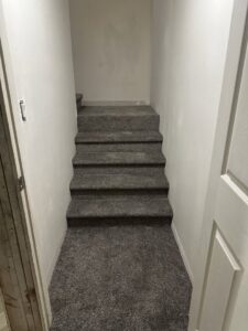 Newly installed grey carpet on a residential basement staircase by All about flooring utah in Salt Lake City, UT.