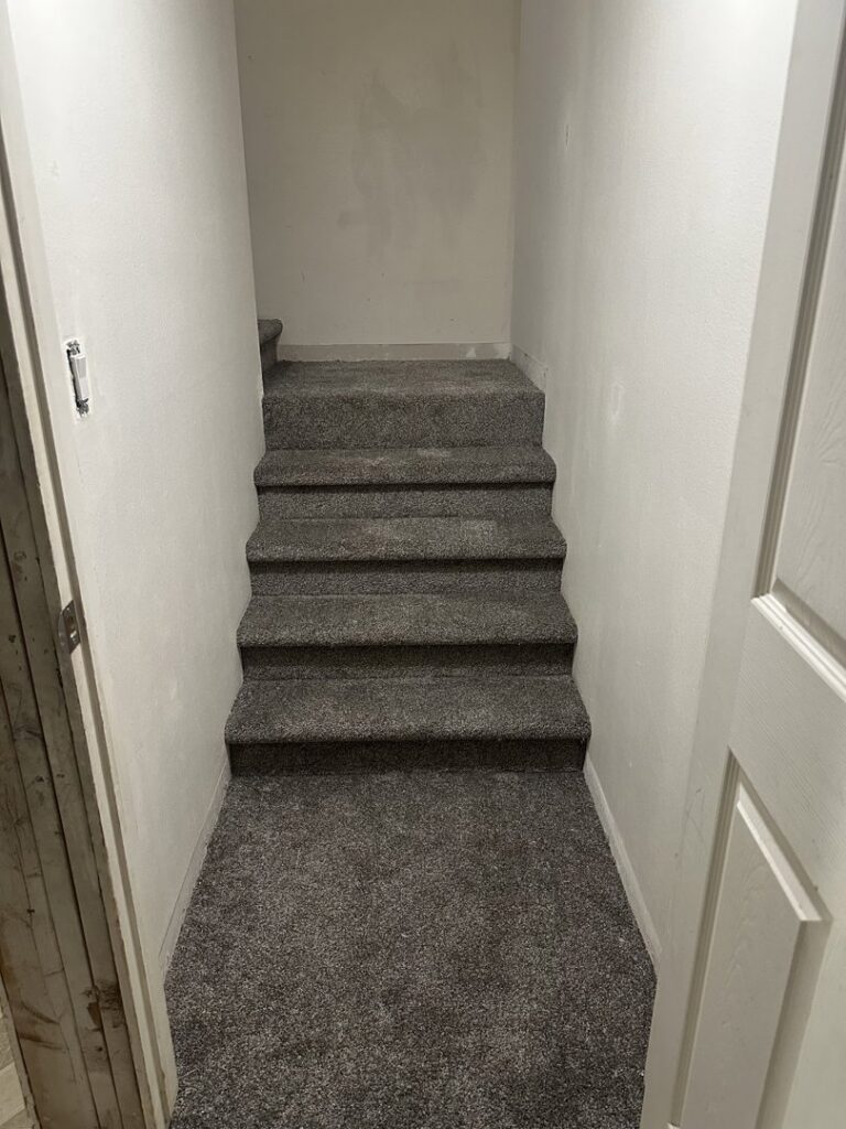 Newly installed grey carpet on a residential basement staircase by All about flooring utah in Salt Lake City, UT.