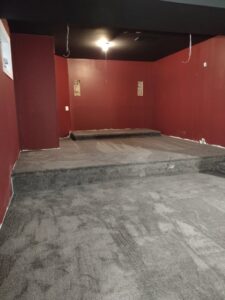 A room with grey carpet and a custom raised platform installed by New City Carpet And Flooring in Chicago, IL