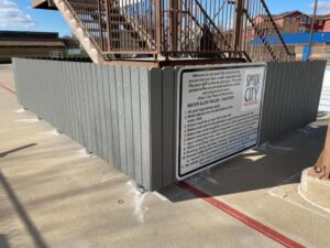 A grey composite privacy fence installed around a public pool area by Bostwick Fencing, LLC in Sioux City, IA.