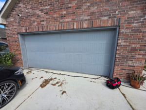 A newly installed grey garage door on a brick home by Legacy Garage Doors & Repairs in Church Point, LA.