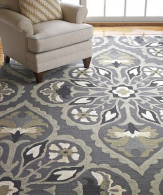 A room showcasing a large grey patterned area rug next to an armchair, from Odino Designs, llc in Portland, OR.